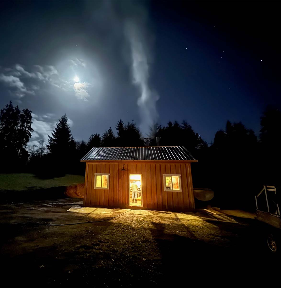 A shot of the Condea's Farm sugar shack all lit up at night.